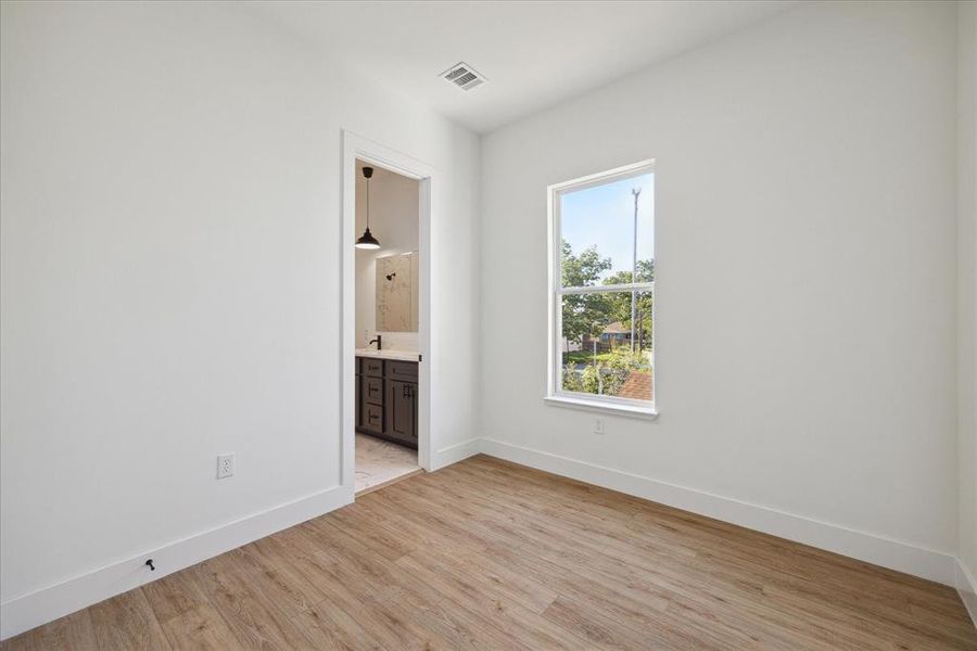 Bedroom features recessed lighting and large windows.