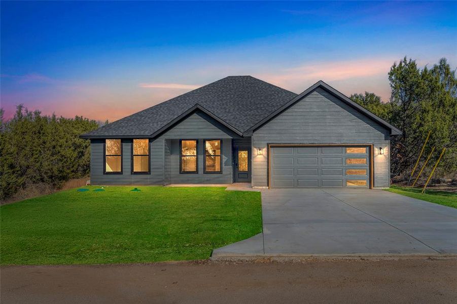 View of front of home featuring a garage and a yard