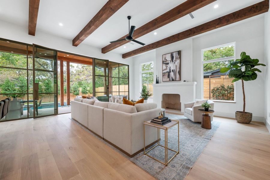 Living room featuring light wood-type flooring, recessed lighting, a fireplace, a ceiling fan, and beamed ceiling Living room featuring light wood-type flooring, recessed lighting, a fireplace, a ceiling fan, and beamed ceiling