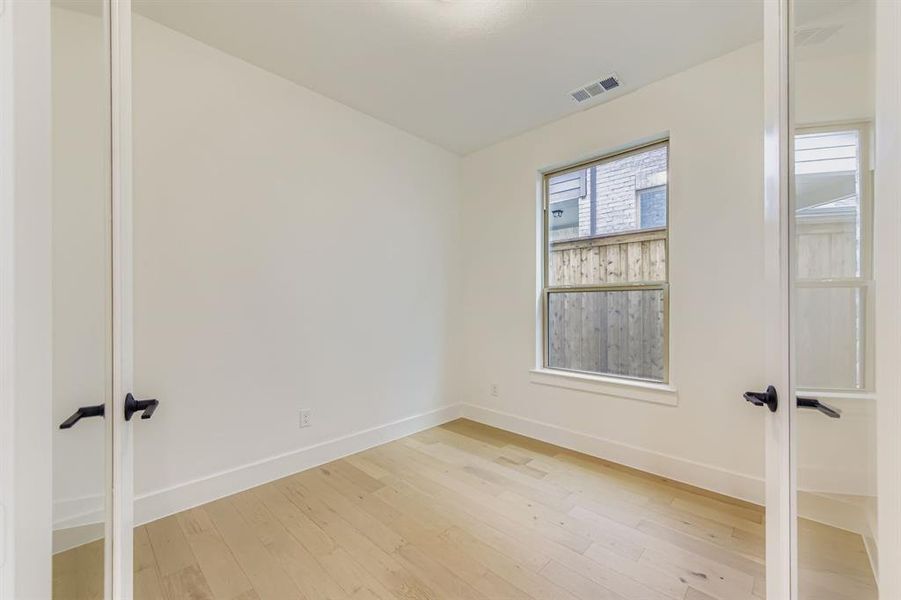 Empty room featuring light wood-style flooring and french doors Empty room featuring light wood-style flooring and french doors
