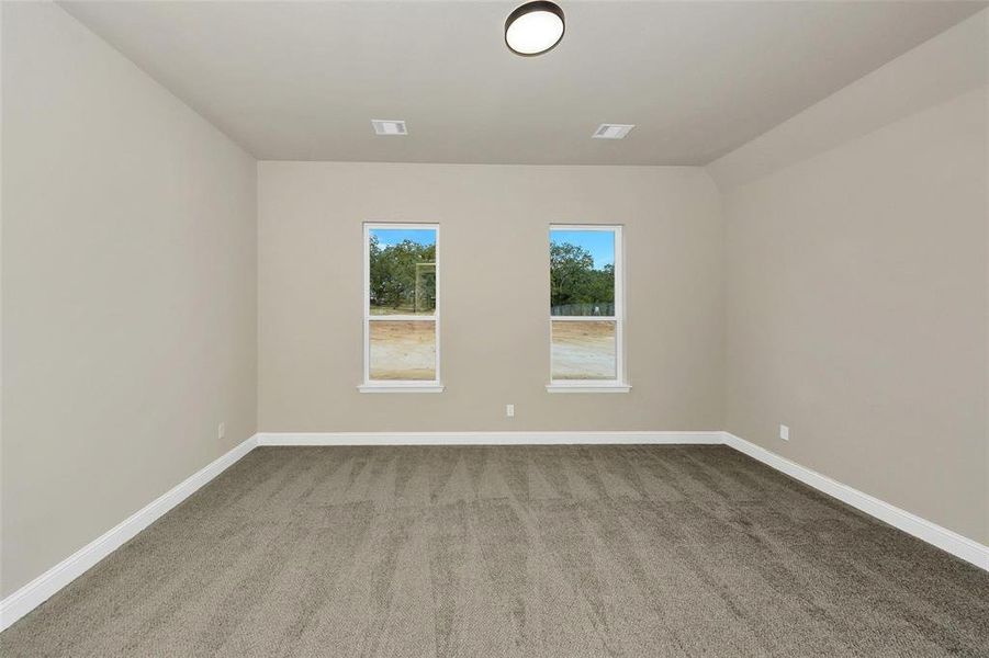 Unfurnished room featuring light carpet and baseboards