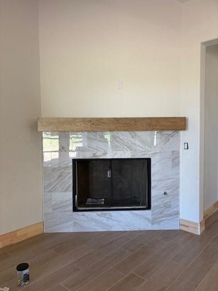 Detailed view of wood tiled floors and a high end fireplace