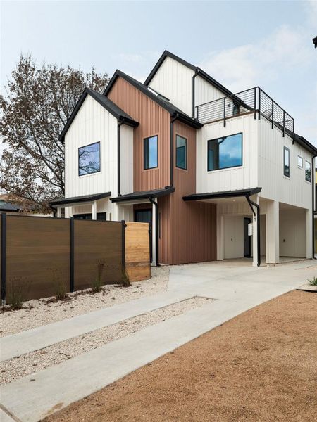 Modern farmhouse with a carport, driveway, and board and batten siding