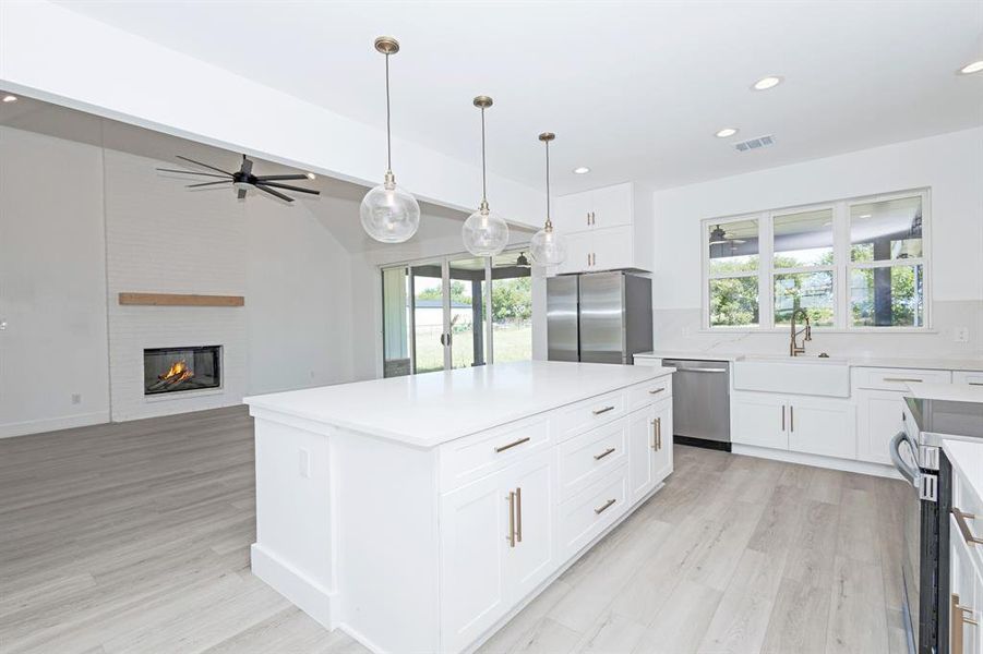 Kitchen with healthy amount of natural light, recessed lighting, stainless steel appliances, light wood-style flooring, and vaulted ceiling
