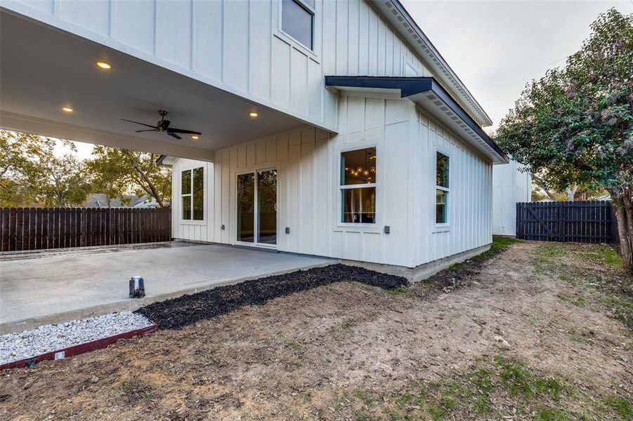 View of side of home with ceiling fan and a patio area