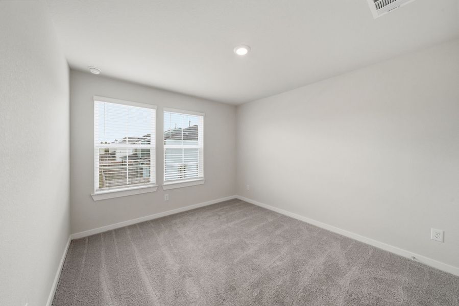 A room with a window and a carpet.