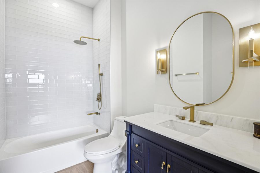 Bathroom featuring bathing tub / shower combination, vanity, and light wood-type flooring