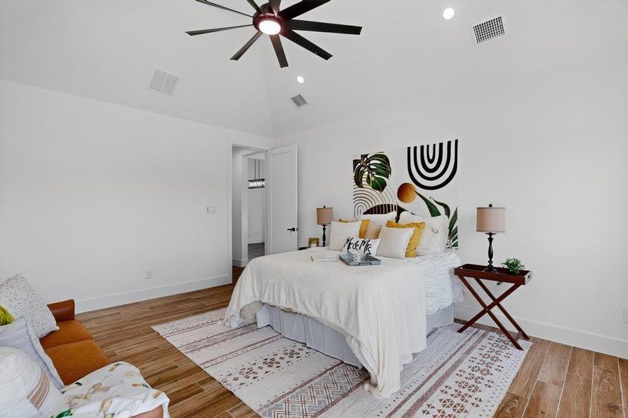 Bedroom with wood finished floors, lofted ceiling, ceiling fan, and recessed lighting