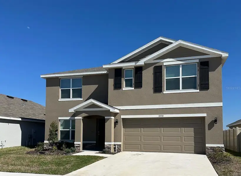 Front exterior of a new home in Berry Bay, Wimauma, FL, highlighting curb appeal (Image 6).