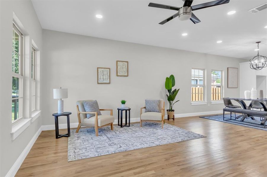 Living area with light wood-style flooring, ceiling fan, recessed lighting, and a chandelier