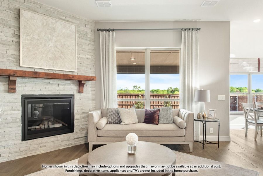 Living room with stone fireplace, wood mantel, light sofa, and large windows with natural light