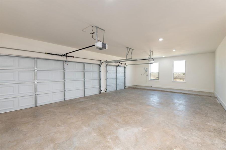 Garage with a garage door opener and baseboards