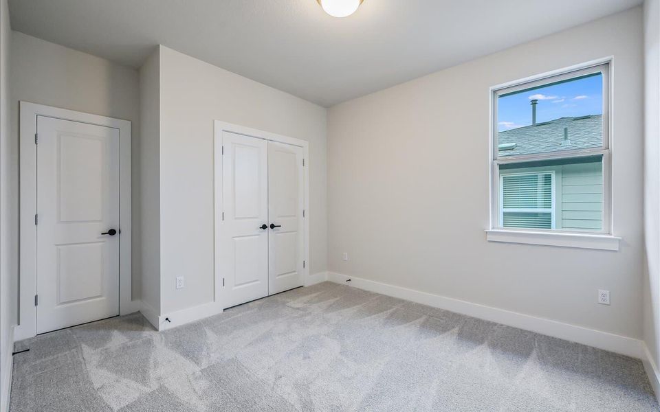 Unfurnished bedroom with light colored carpet and a closet