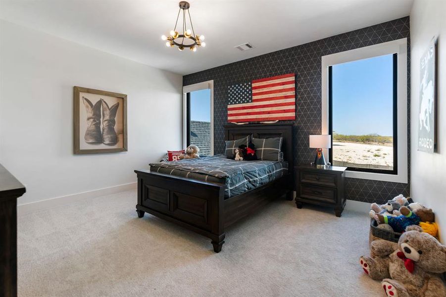 Carpeted bedroom with an accent wall and a chandelier Carpeted bedroom with an accent wall and a chandelier