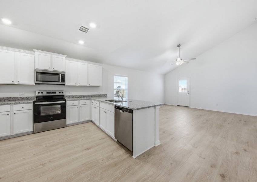 Kitchen featuring a stainless steel range and refrigerator, granite countertops, and white cabinetry. Kitchen featuring a stainless steel range and refrigerator, granite countertops, and white cabinetry.