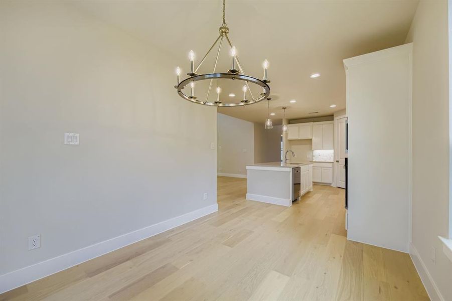 Unfurnished dining area with a chandelier, recessed lighting, and light wood-style flooring Unfurnished dining area with a chandelier, recessed lighting, and light wood-style flooring