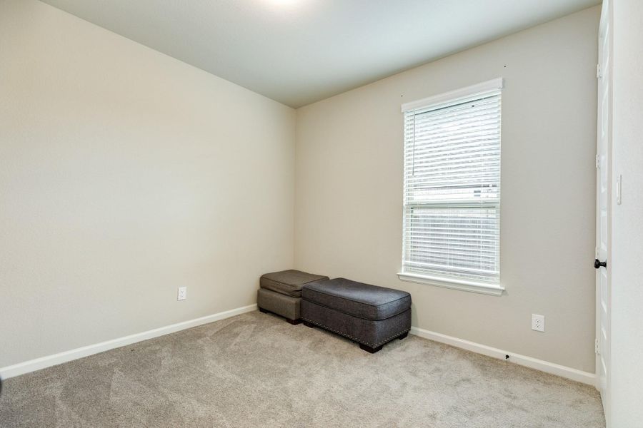 Secondary bedroom featuring like-new carpet and an oversized window. Secondary bedroom featuring like-new carpet and an oversized window.