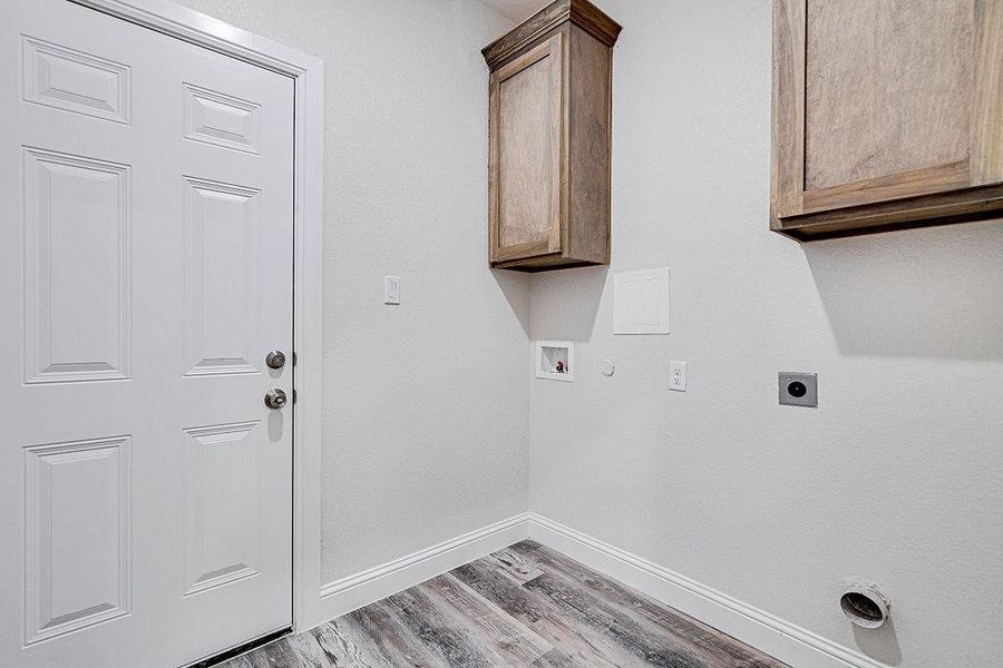 Washroom featuring hookup for an electric dryer, hookup for a gas dryer, cabinets, hookup for a washing machine, and light hardwood / wood-style flooring