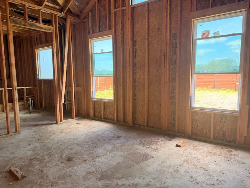 Framed interior space with new window installations awaiting final finishes.
