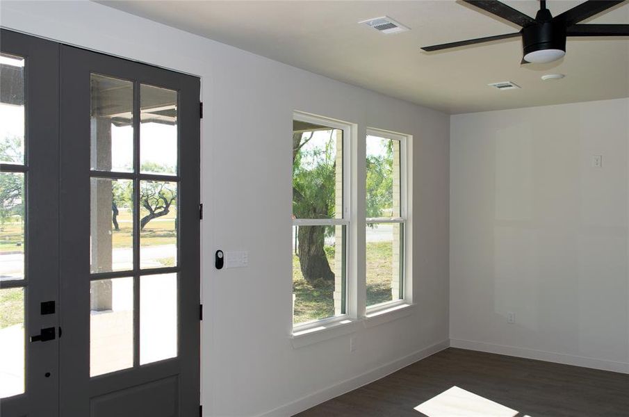 Doorway to outside with healthy amount of natural light, ceiling fan, wood finished floors, and french doors Doorway to outside with healthy amount of natural light, ceiling fan, wood finished floors, and french doors