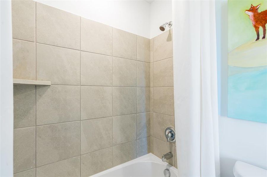 Bathroom with toilet and shower / bathtub combination with curtain