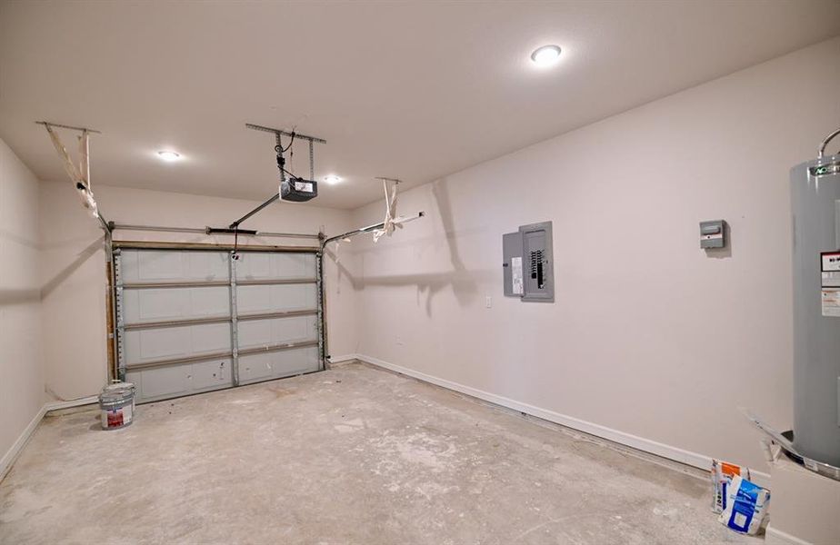 Garage with electric panel, a garage door opener, and water heater