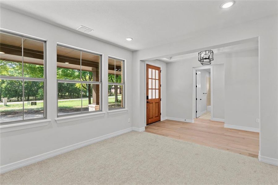 Hallway featuring light colored carpet and a raised ceiling