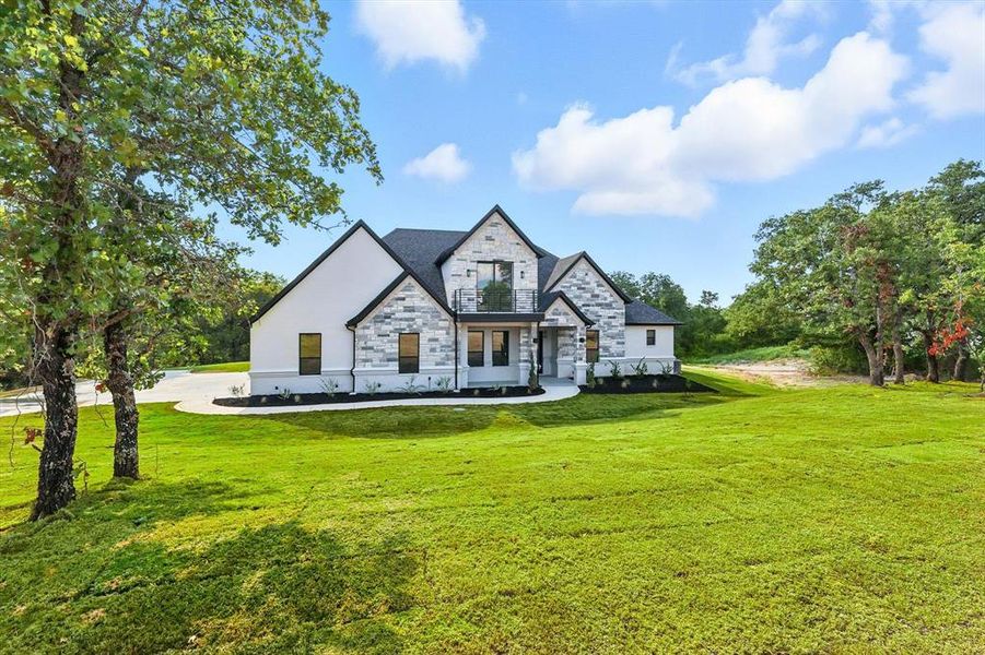 View of front of property with stone siding and a front lawn View of front of property with stone siding and a front lawn