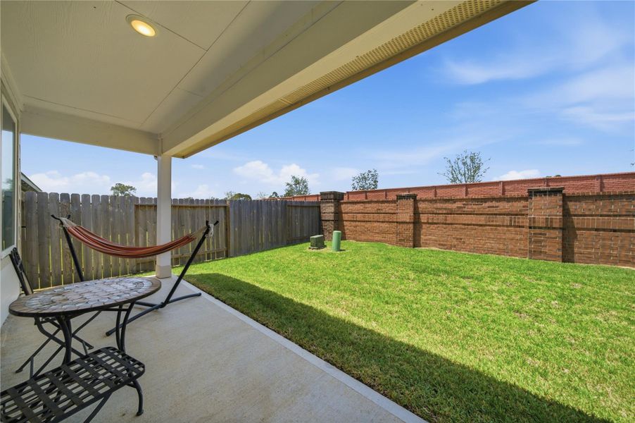 A covered patio in a private back yard.