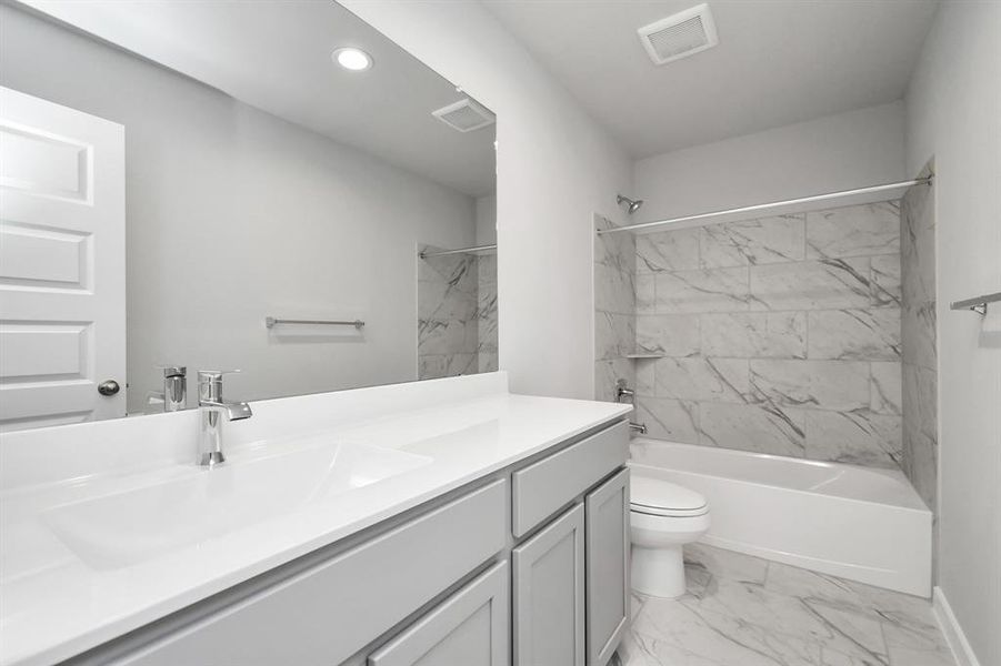 Secondary bathroom equipped with shower/tub combo.