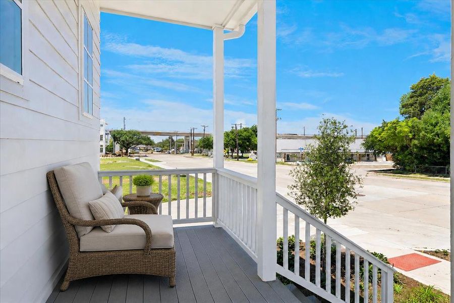 Inviting front porch featuring white siding, white railings, and durable gray decking