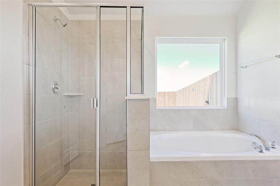 Bathroom featuring shower with separate bathtub and plenty of natural light