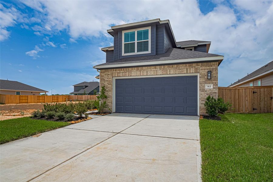 Front exterior of a new home in La Segarra, Brookshire, TX, highlighting curb appeal (Image 1).