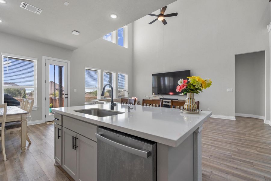 High ceilings and a stone-topped island define this central gathering space.