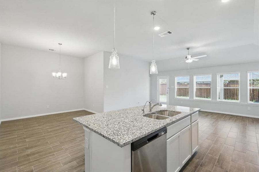 Kitchen featuring dishwasher, open floor plan, wood finished floors, healthy amount of natural light, and recessed lighting Kitchen featuring dishwasher, open floor plan, wood finished floors, healthy amount of natural light, and recessed lighting