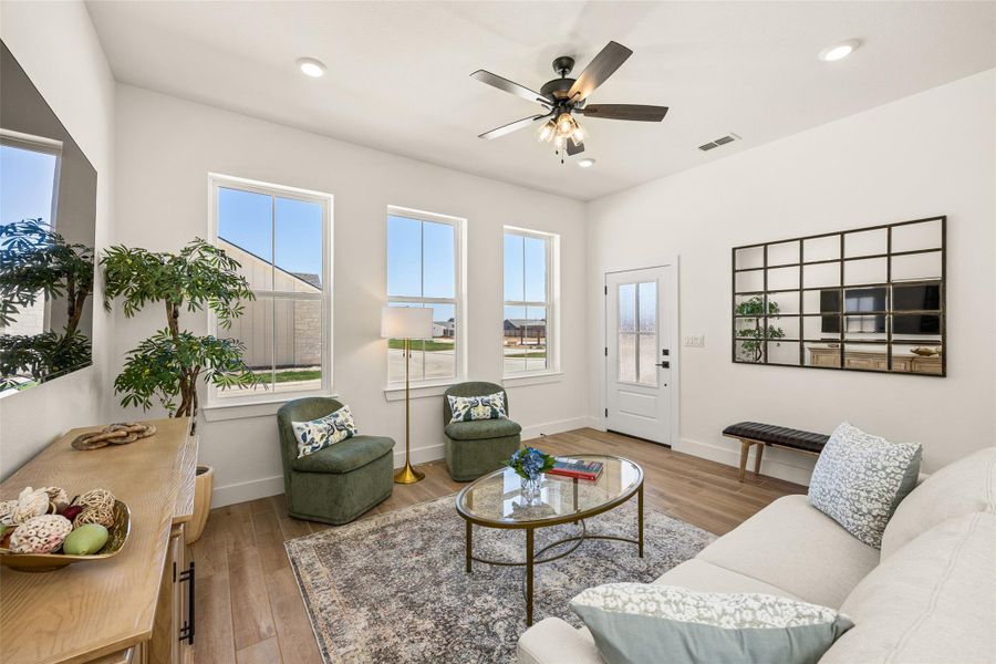 Sun-filled living space features warm wood flooring and an inviting ambiance, perfect for relaxation or entertaining.