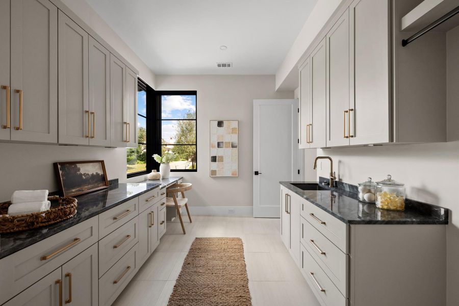 The expansive laundry room is thoughtfully positioned for long-term living, featuring extensive storage and premium utility