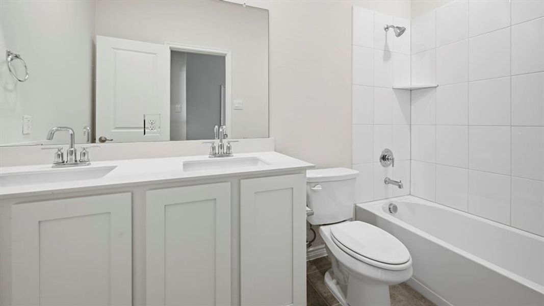 Bathroom featuring double vanity and washtub / shower combination Bathroom featuring double vanity and washtub / shower combination
