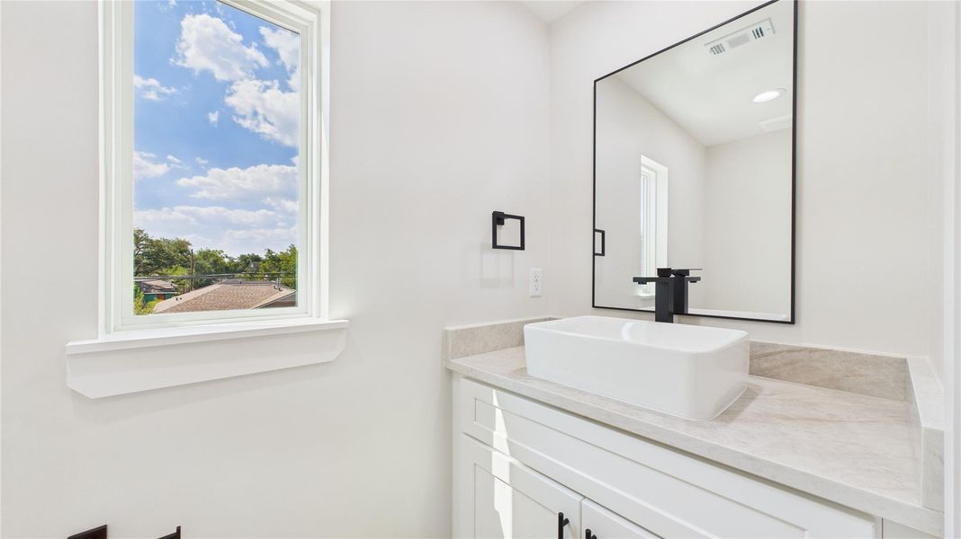 Bright and modern bathroom with a sleek white vanity.