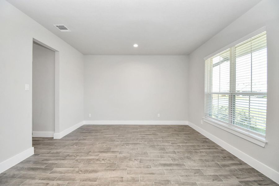 Create lasting memories with your family and friends at the dining table! This expansive dining room showcases sophisticated flooring, custom paint, and seamlessly connects to the family room and kitchen, providing an open and inviting atmosphere. Sample photo of completed home with similar floor plan. Actual colors and selections may vary.