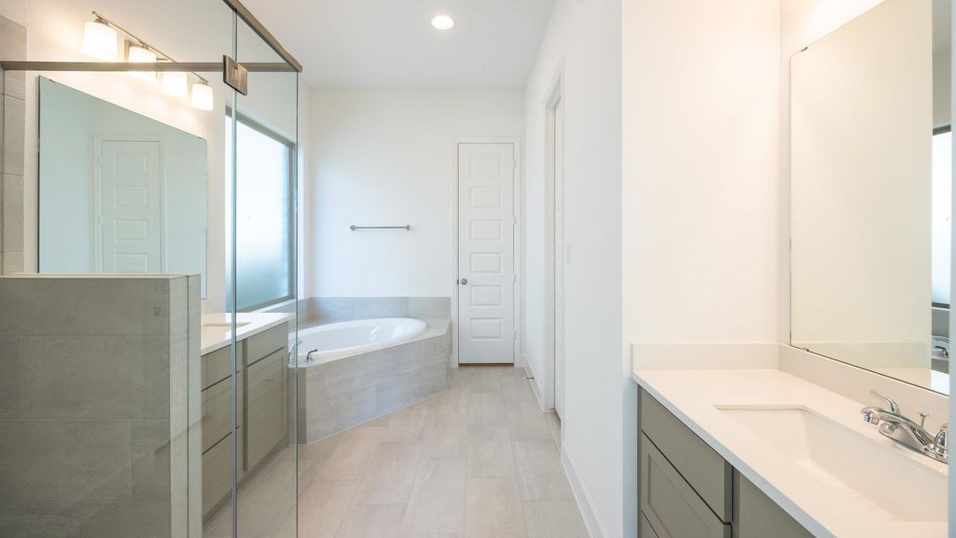 Full bath featuring a garden tub, a stall shower, vanity, and recessed lighting Full bath featuring a garden tub, a stall shower, vanity, and recessed lighting