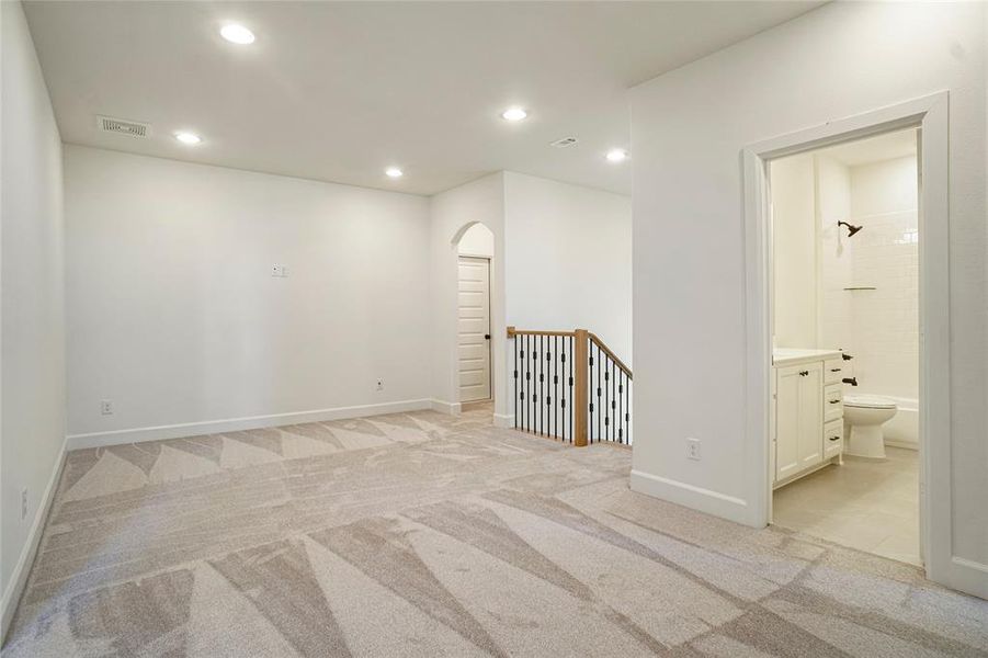Spare room featuring recessed lighting, light carpet, and arched walkways