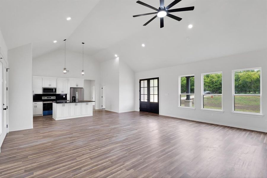 Open-concept living space featuring vaulted ceilings, recessed lighting, and a contemporary ceiling fan