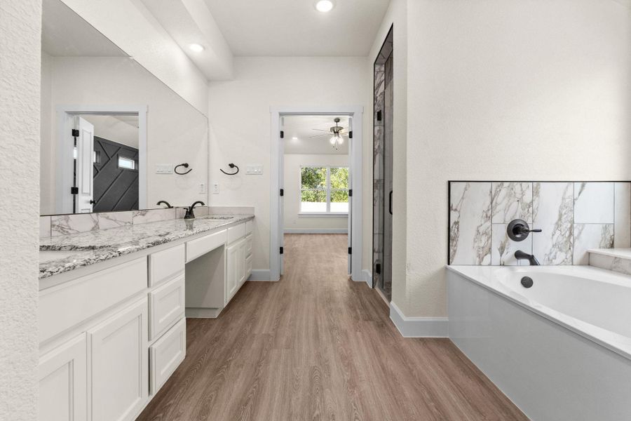 Bathroom with double vanity, light wood-type flooring, a bath, recessed lighting, and a shower stall