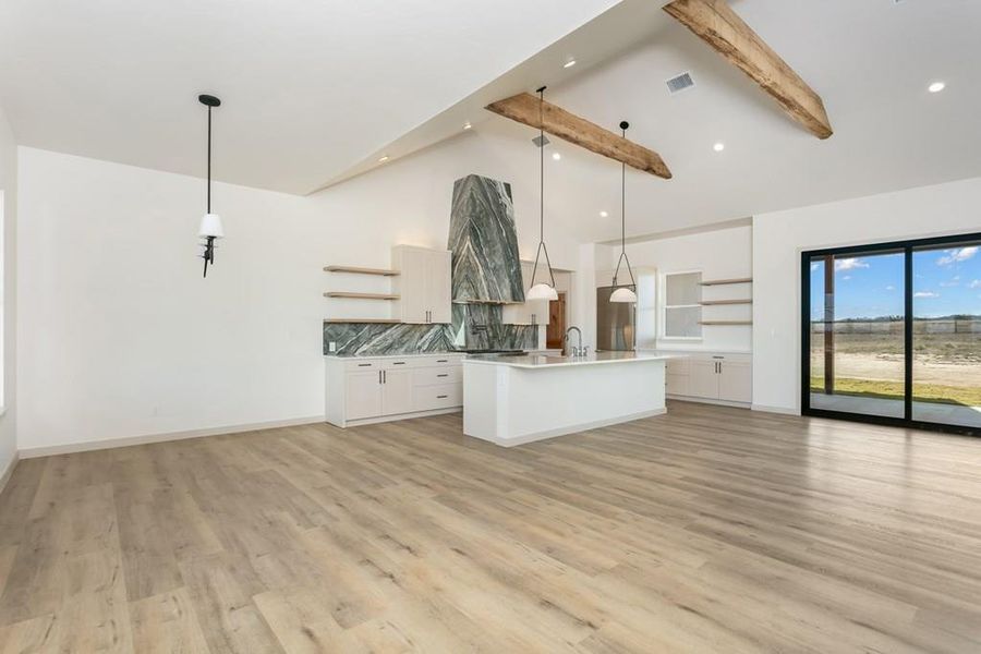 Kitchen with open shelves, white cabinets, open floor plan, pendant lighting, and beamed ceiling Kitchen with open shelves, white cabinets, open floor plan, pendant lighting, and beamed ceiling