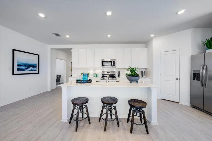 Kitchen with stainless steel appliances, an island with sink, light wood-style floors, recessed lighting, and backsplash