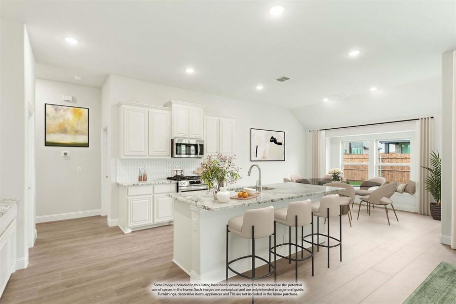 Open-concept kitchen with white cabinets, granite island, and adjoining living and dining area with hardwood floors Open-concept kitchen with white cabinets, granite island, and adjoining living and dining area with hardwood floors