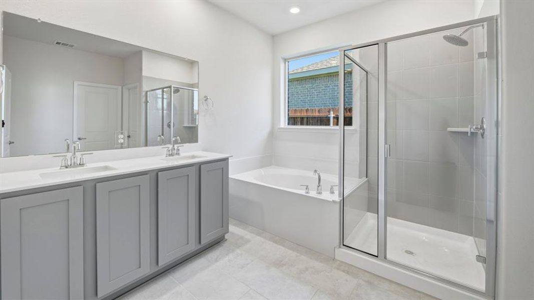 Bathroom with double vanity, a stall shower, a garden tub, and light tile patterned flooring Bathroom with double vanity, a stall shower, a garden tub, and light tile patterned flooring