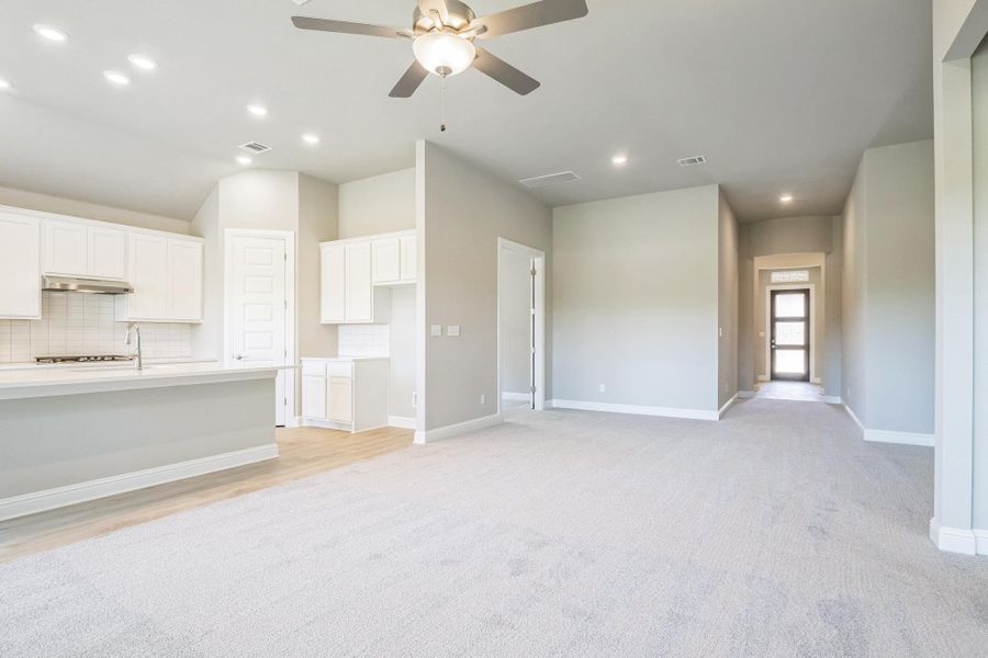 Unfurnished living room featuring baseboards, a ceiling fan, visible vents, and recessed lighting