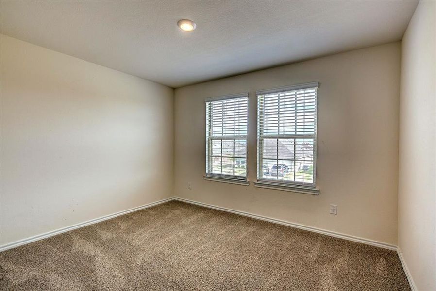 Spare room featuring carpet flooring and baseboards
